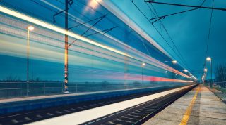 Light trail of the express train in the railway station at the night.