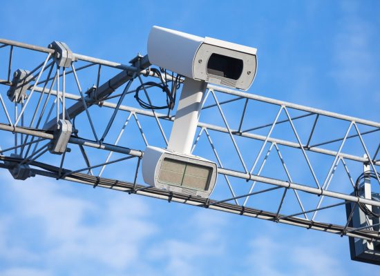 Traffic enforcement camera closeup photo over blue sky